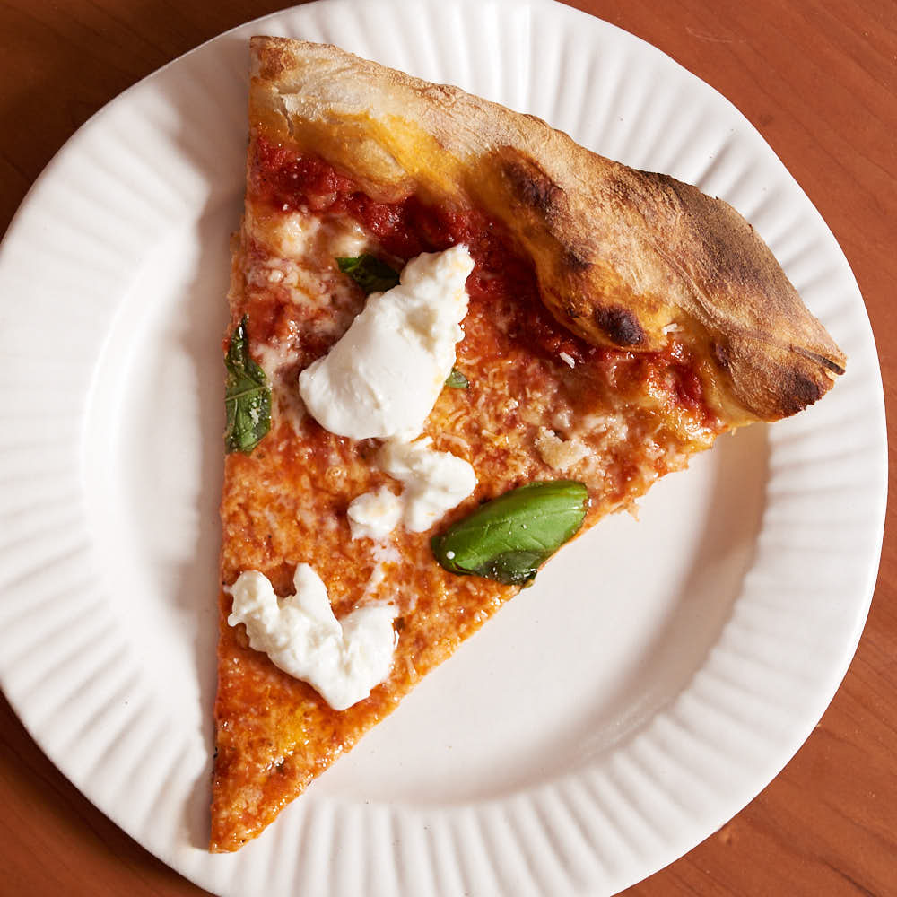 Pizza with aged mozzarella, tomato sauce, and Parmesan Reggiano, with burrata, basil and Parmesan Reggiano added post-bake, inspired by L’industrie Pizzeria’s burrata slice. Baked in a commercial deck oven.