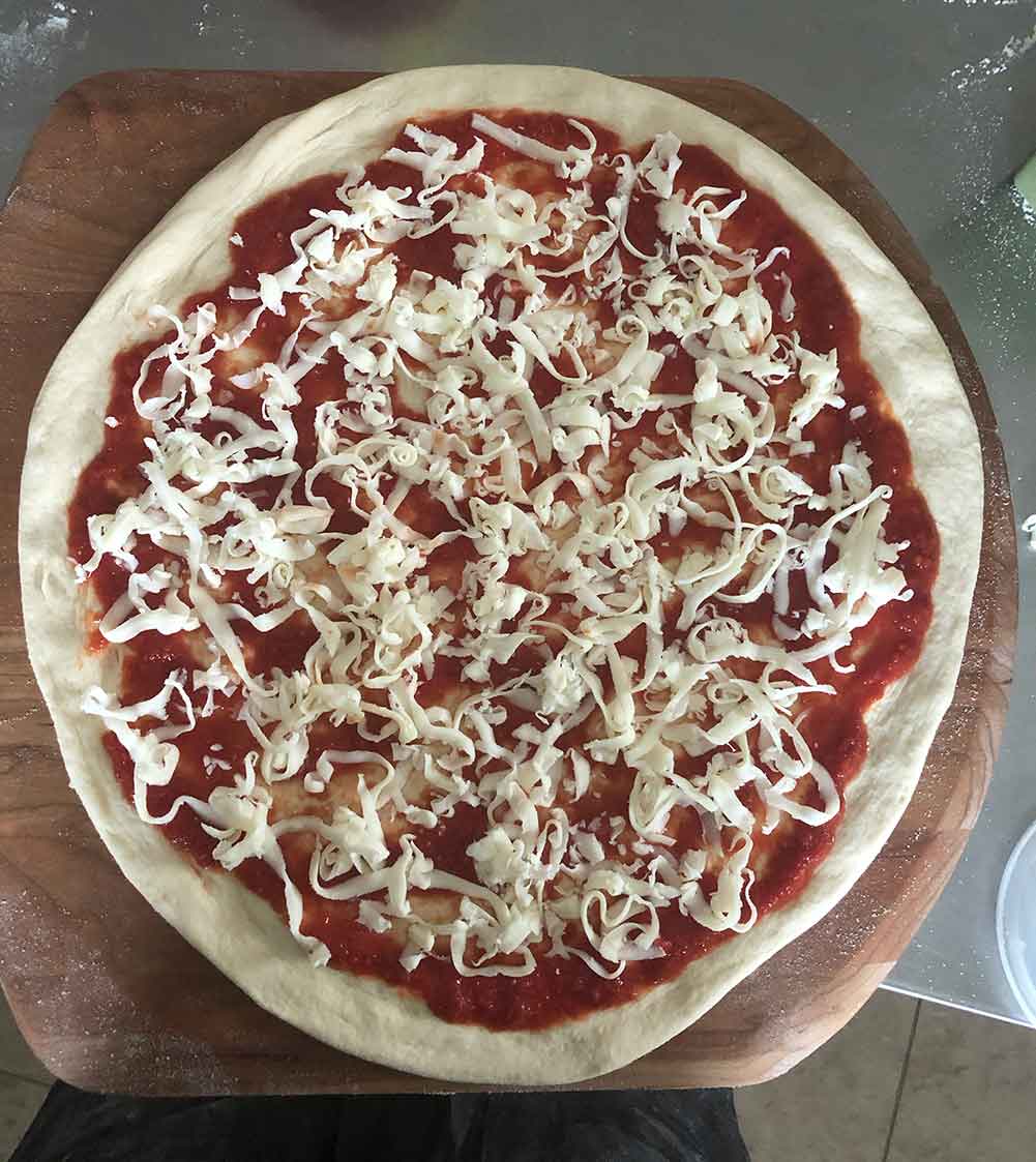 A stretched, sauced, and cheesed dough.