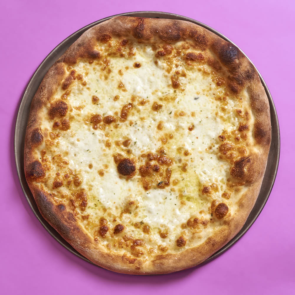 A white pizza with aged mozzarella, fresh mozzarella, and oregano. Baked in a typical home oven on a 3/8-inch-thick steel plate.